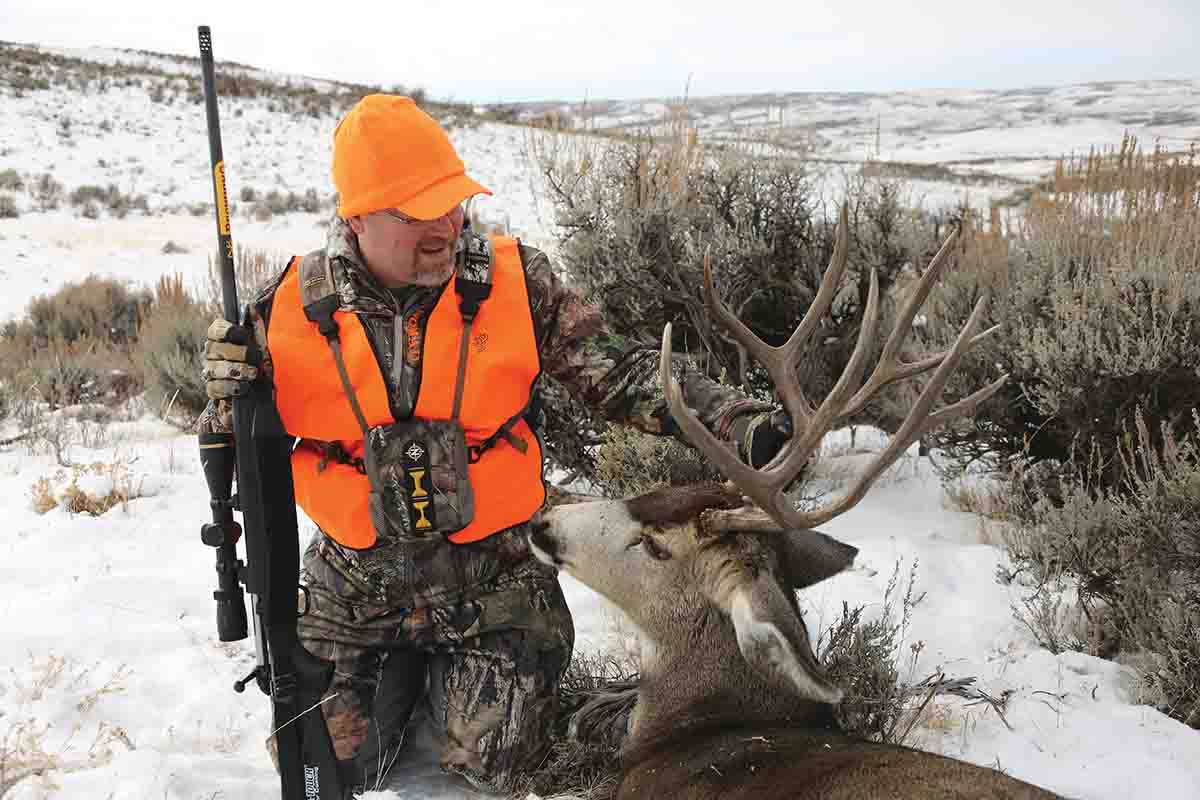 Brad admires the mature buck he shot during a Colorado migration hunt.